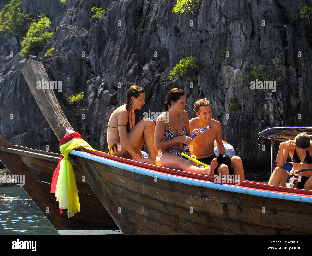 Young people prepare to snorkel from longtail boat Ko Ma island near Ko Ngai Thailand Stock Photo