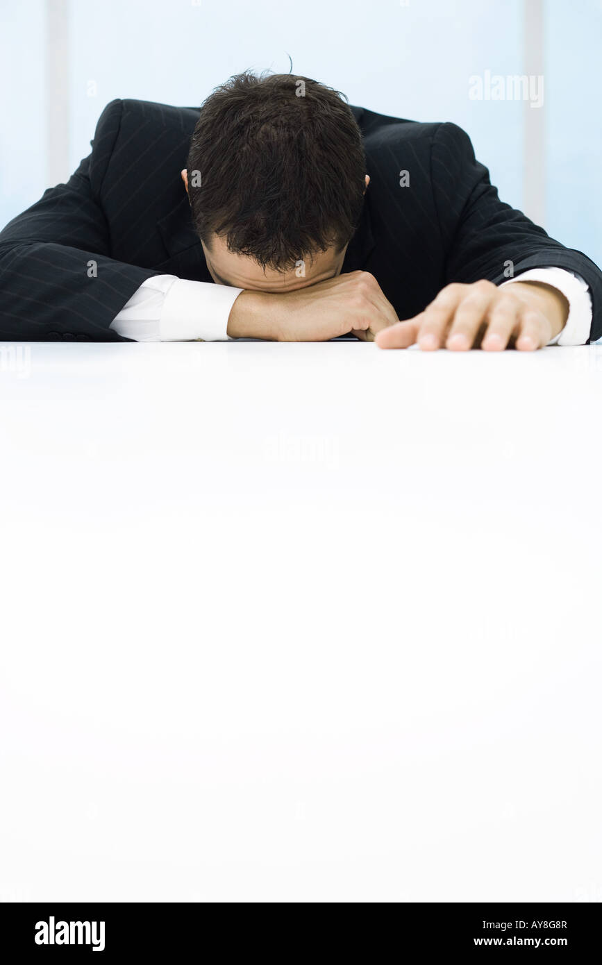 Businessman with head down on table Stock Photo