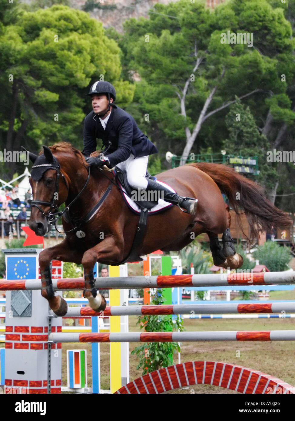horse and rider jumping over obstacle during equestrian competition ...