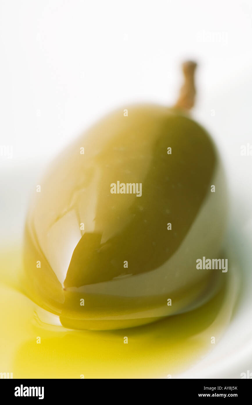 Green olive in olive oil, closeup Stock Photo Alamy