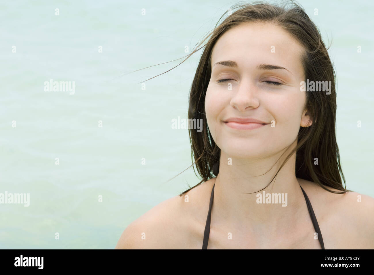Young woman outdoors with eyes closed, smiling, close-up Stock Photo