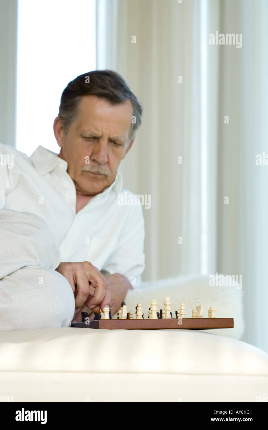 Man studying chessboard Stock Photo