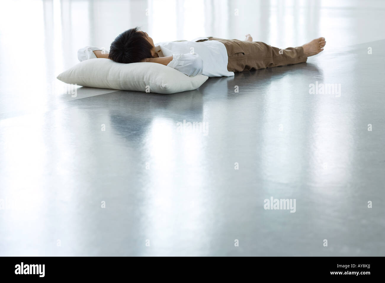 Man lying on floor with head on pillow, full length Stock Photo - Alamy