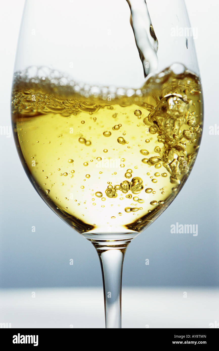 White wine being poured into wine glass, close-up Stock Photo