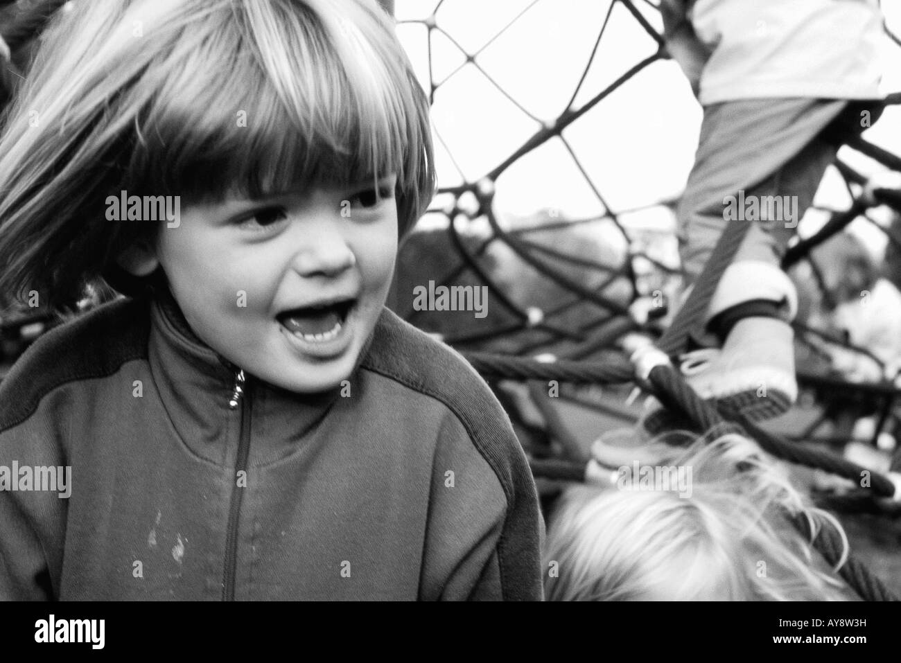 Child on playground looking away, hair tousled by wind, close-up Stock Photo
