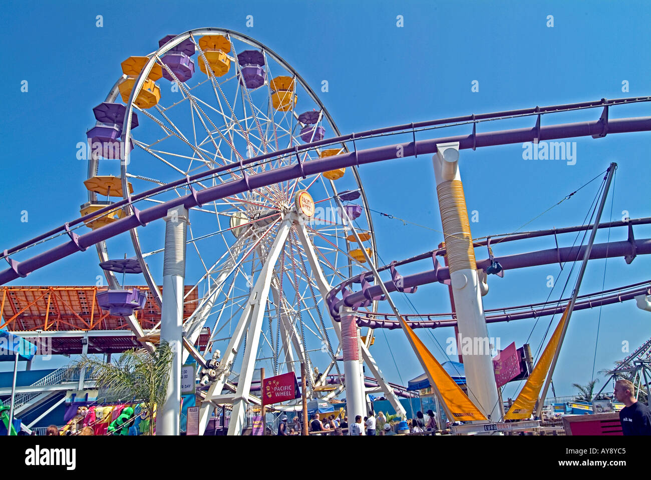 Looking up at Ferris wheel seats, roller coaster, rides on the Santa Monica pier California CA Stock Photo