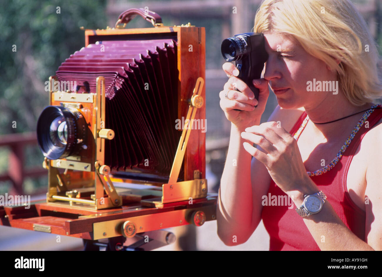 Female photographer standing next to a Wisner wooden field view camera
