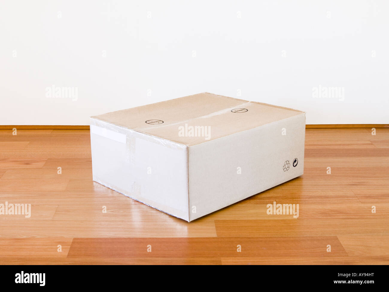 A flatpack cardboard box on a wooden floor Stock Photo Alamy