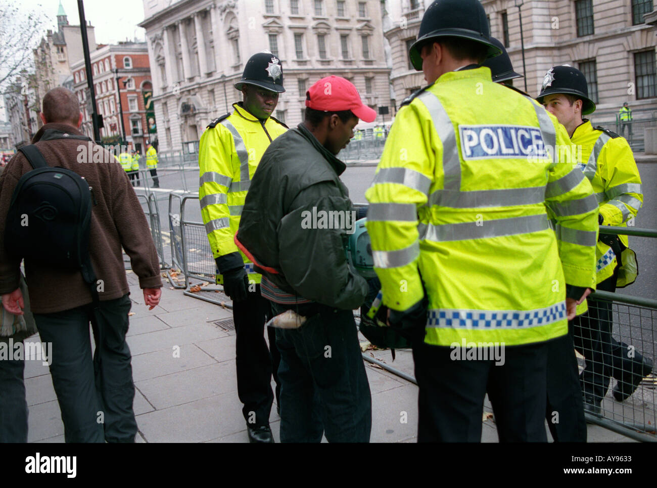 police officers stop and searching young black youth in central London. Stock Photo