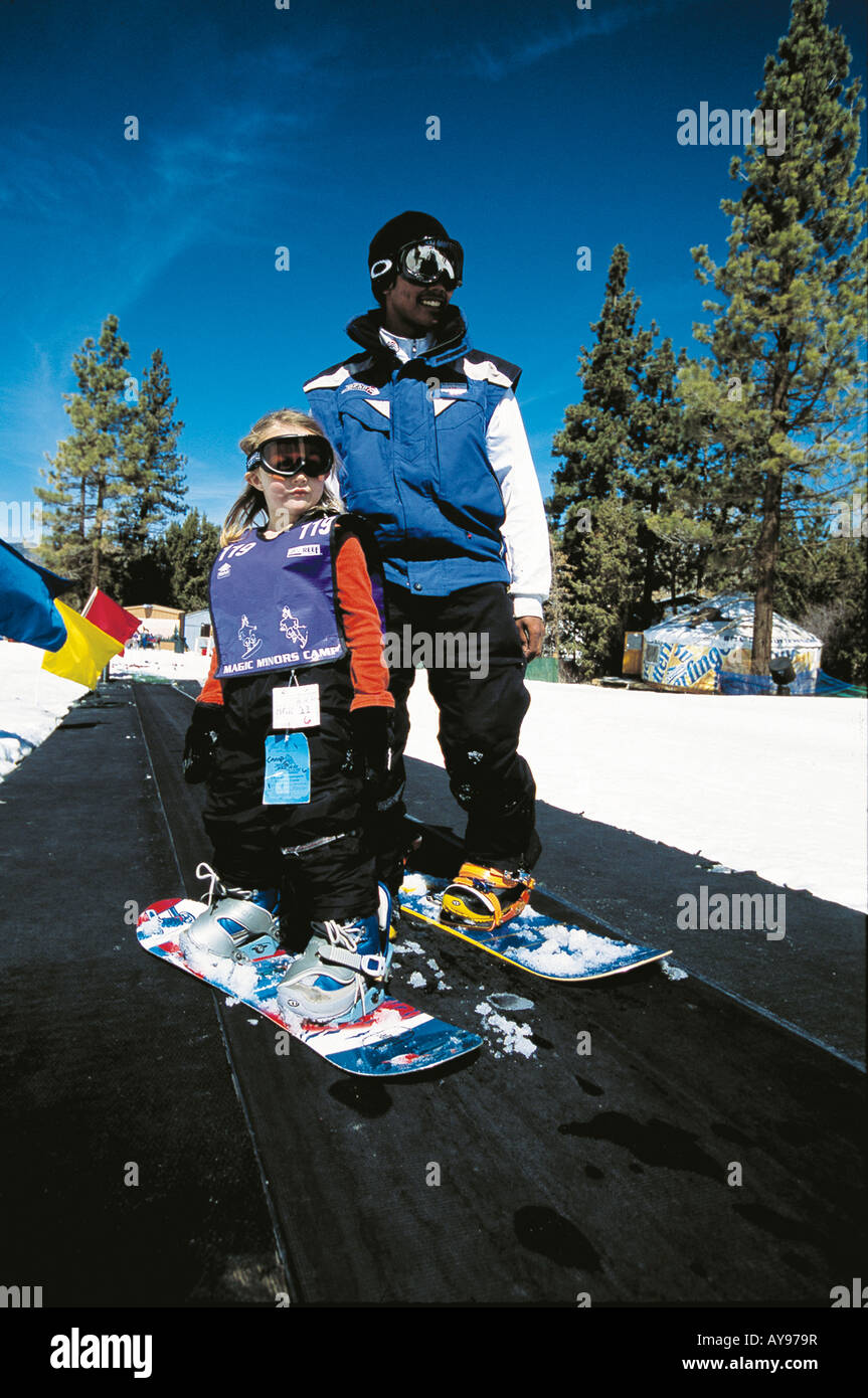 CHILD LEARNING TO SNOWBOARD WITH INSTRUCTOR Stock Photo Alamy