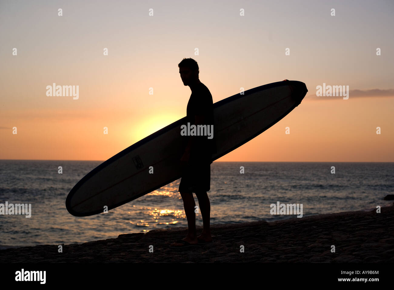 Surfer with board at waters edge, Cornwall Stock Photo