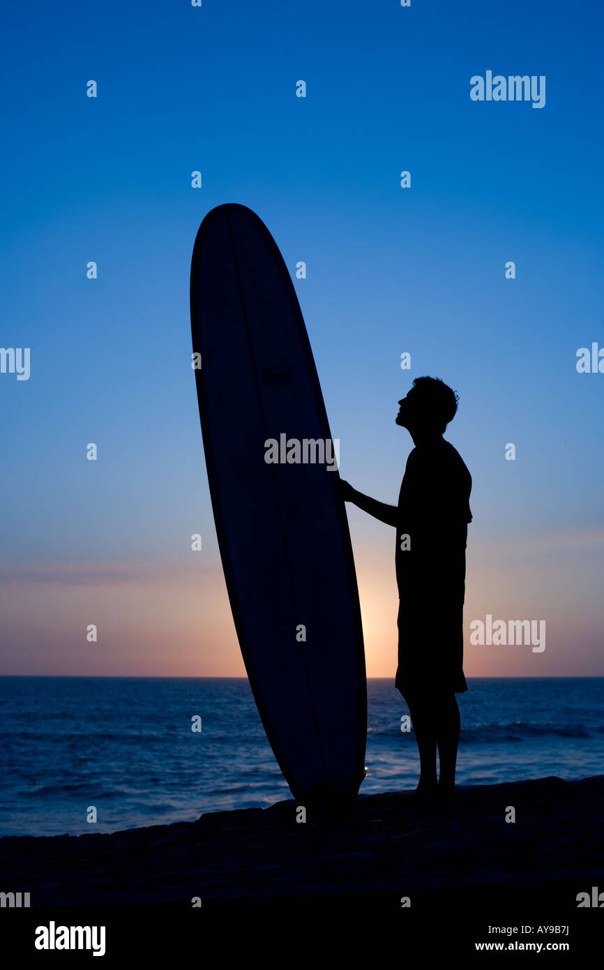 Surfer with board at waters edge, Cornwall Stock Photo