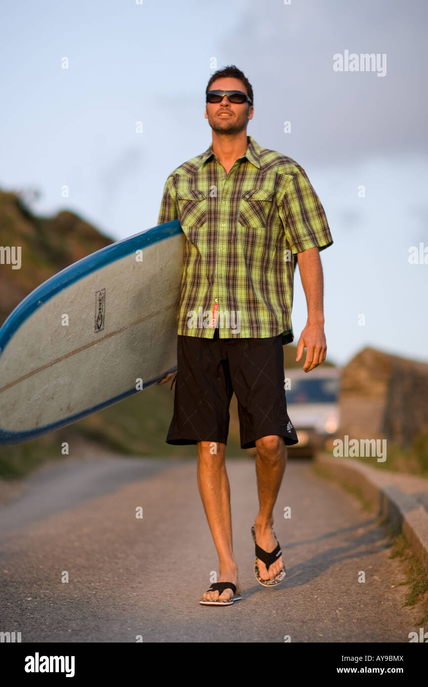 Surfer Gary Green carrying board, Cornwall, UK Stock Photo