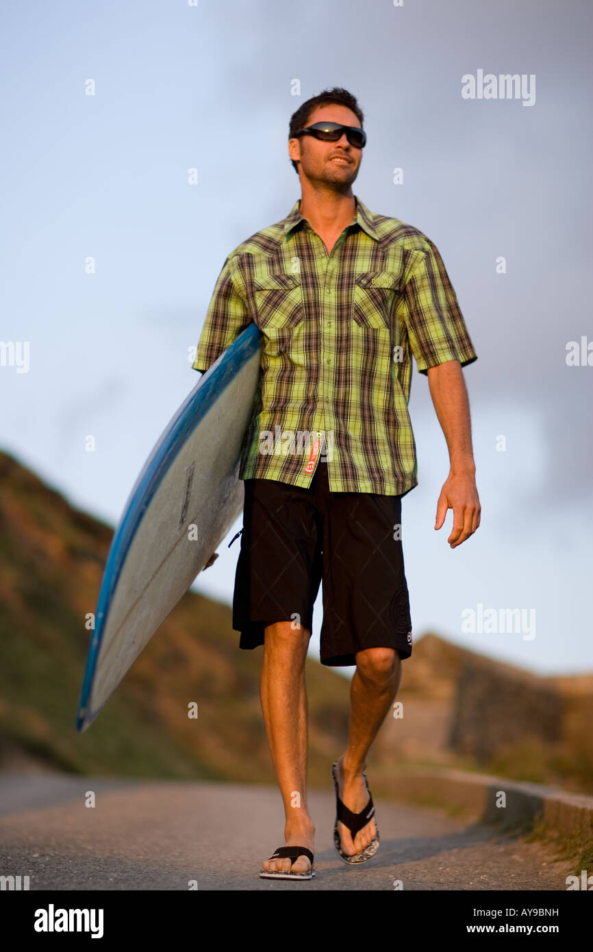 Surfer Gary Green carrying board, Cornwall, UK Stock Photo