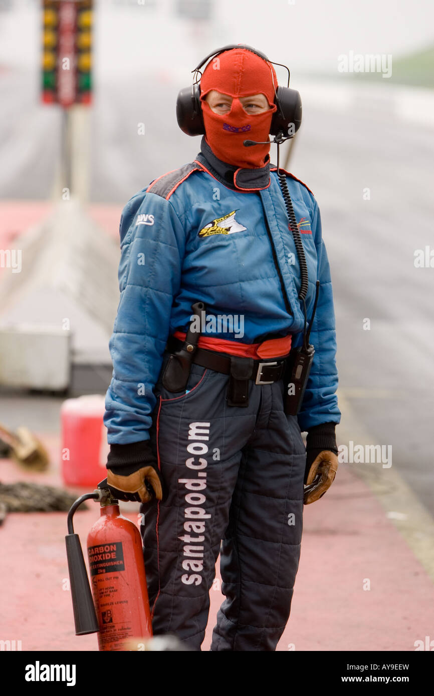 Safety worker with fire extinguisher on car racing track at Santa Pod