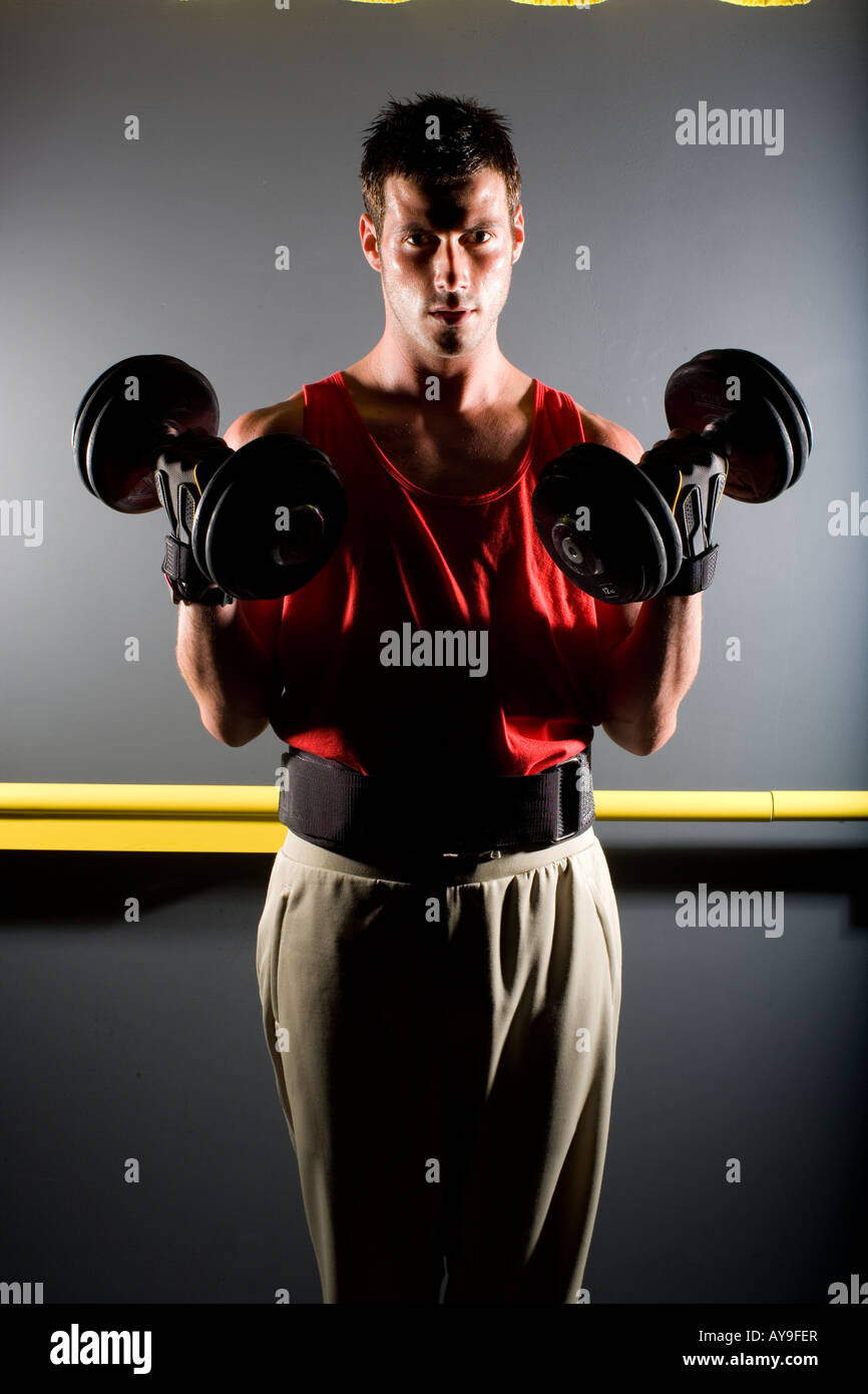 Young man lifting weights, concentration and endurance Stock Photo