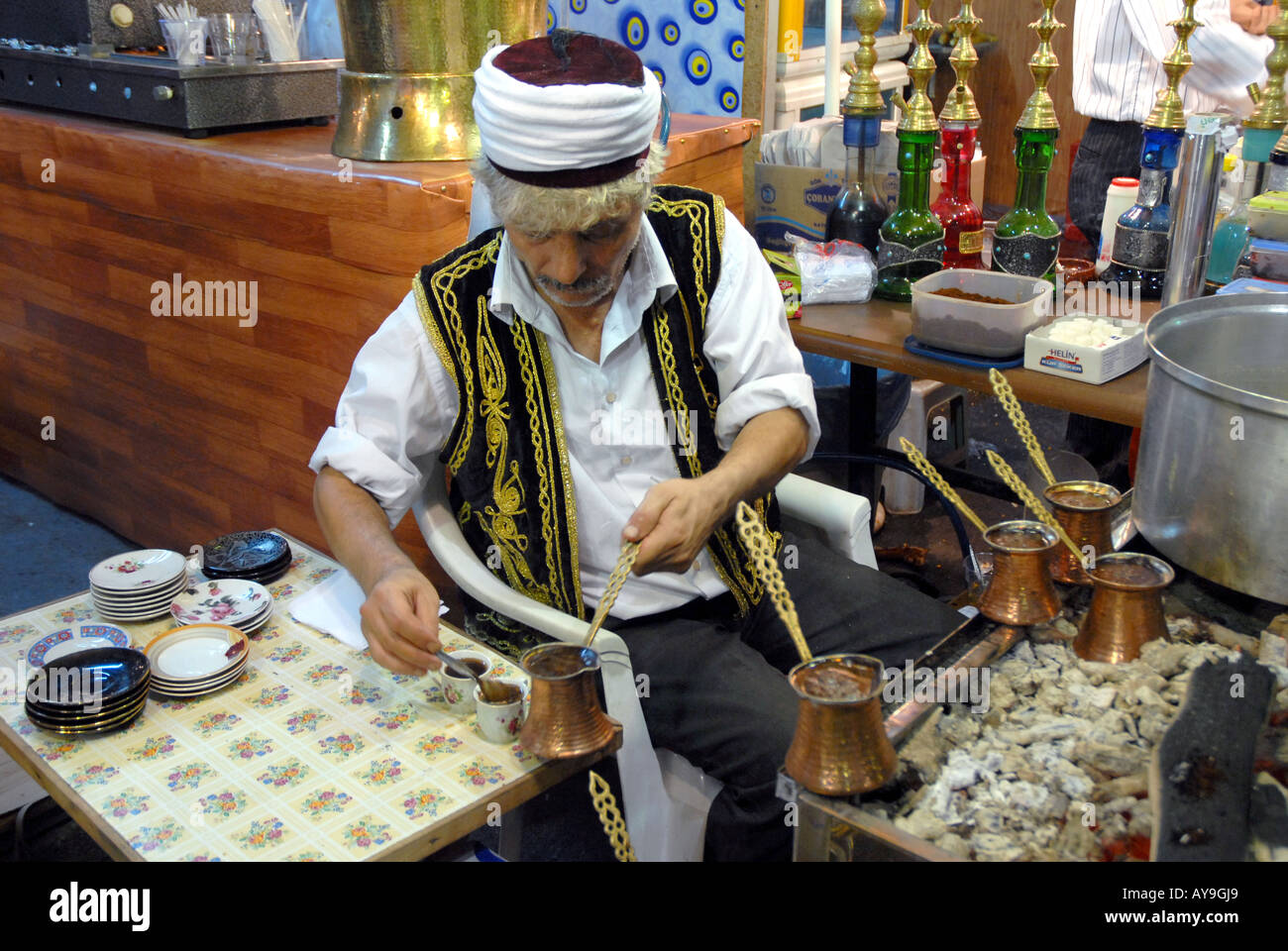 TURKISH MAN IN TRADITIONAL DRESS PREAPERING TURKISH COFFEE Stock Photo