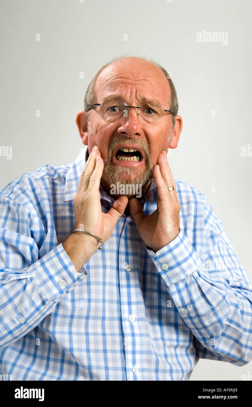 60 year old white man with a a goatee beard and a  facial expression depicting scared horror Stock Photo