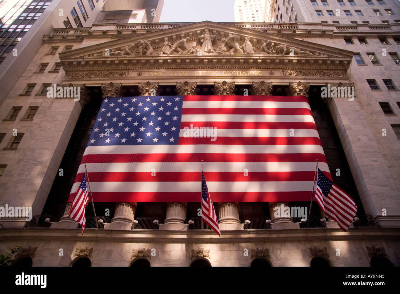 A huge American flag decorates the Greek Revival facade of the Stock Exchange on Broad Street in Manhattan New York City Stock Photo