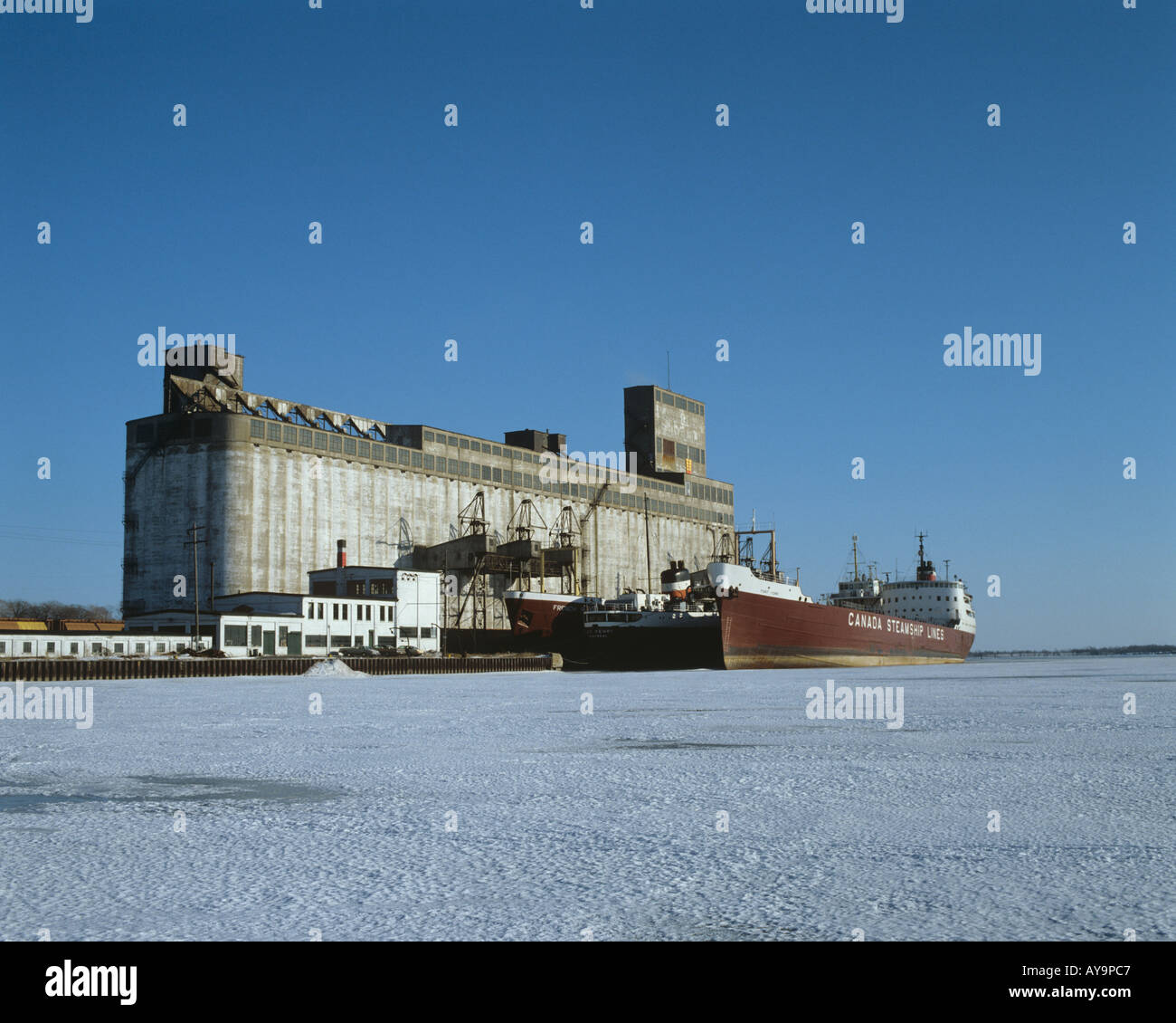 Ships alongside grain elevator locked in Lake Ontario ice for the winter Kingston Ontario Canada Stock Photo