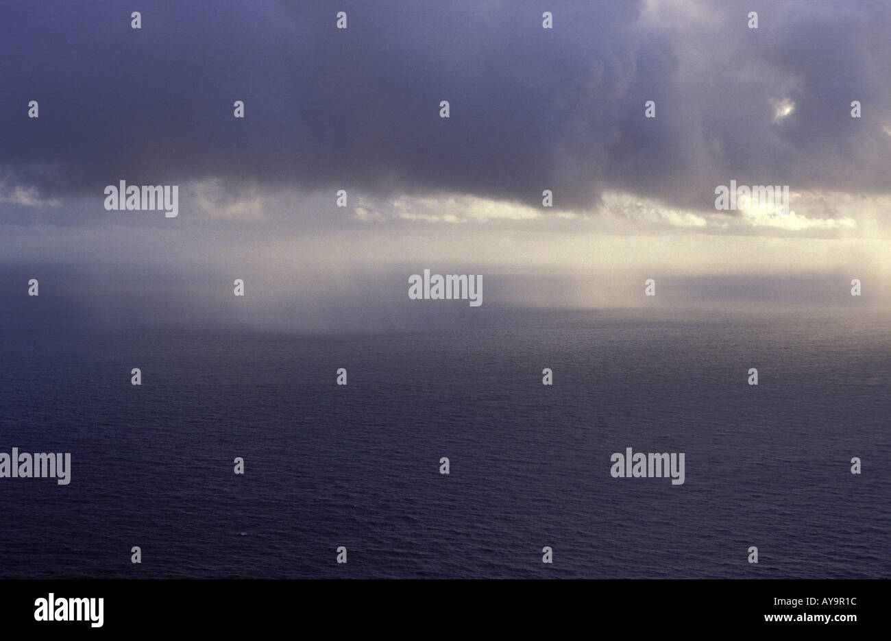 Regenwolken im Morgengrauen ueber dem Meer Stock Photo