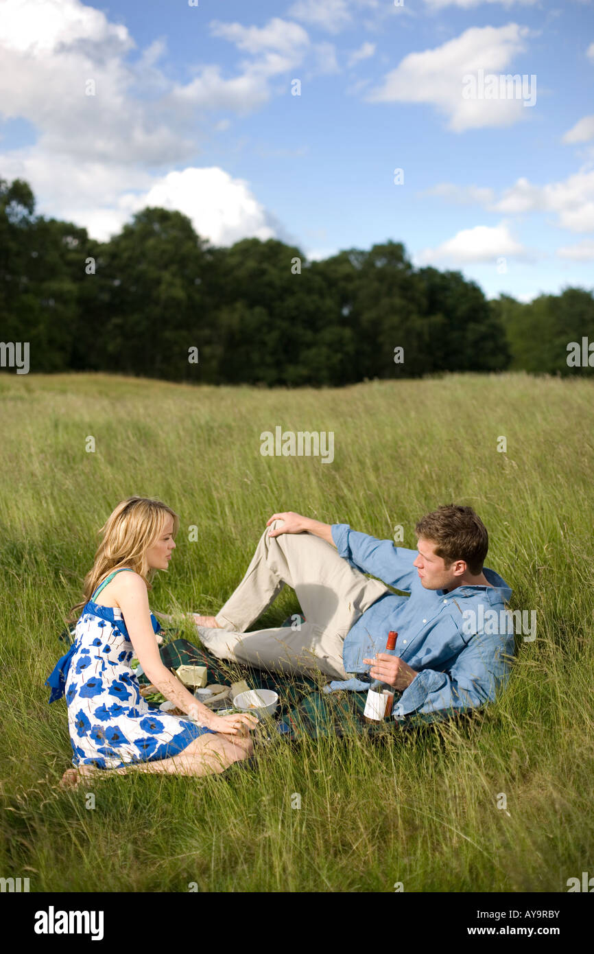 Couple sitting on picnic blanket talking Stock Photo