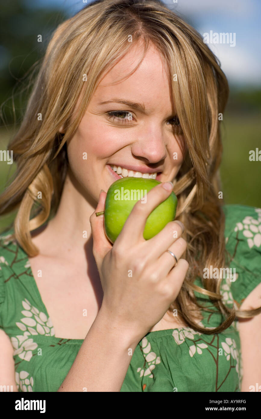 Blonde woman biting fresh apple Stock Photo