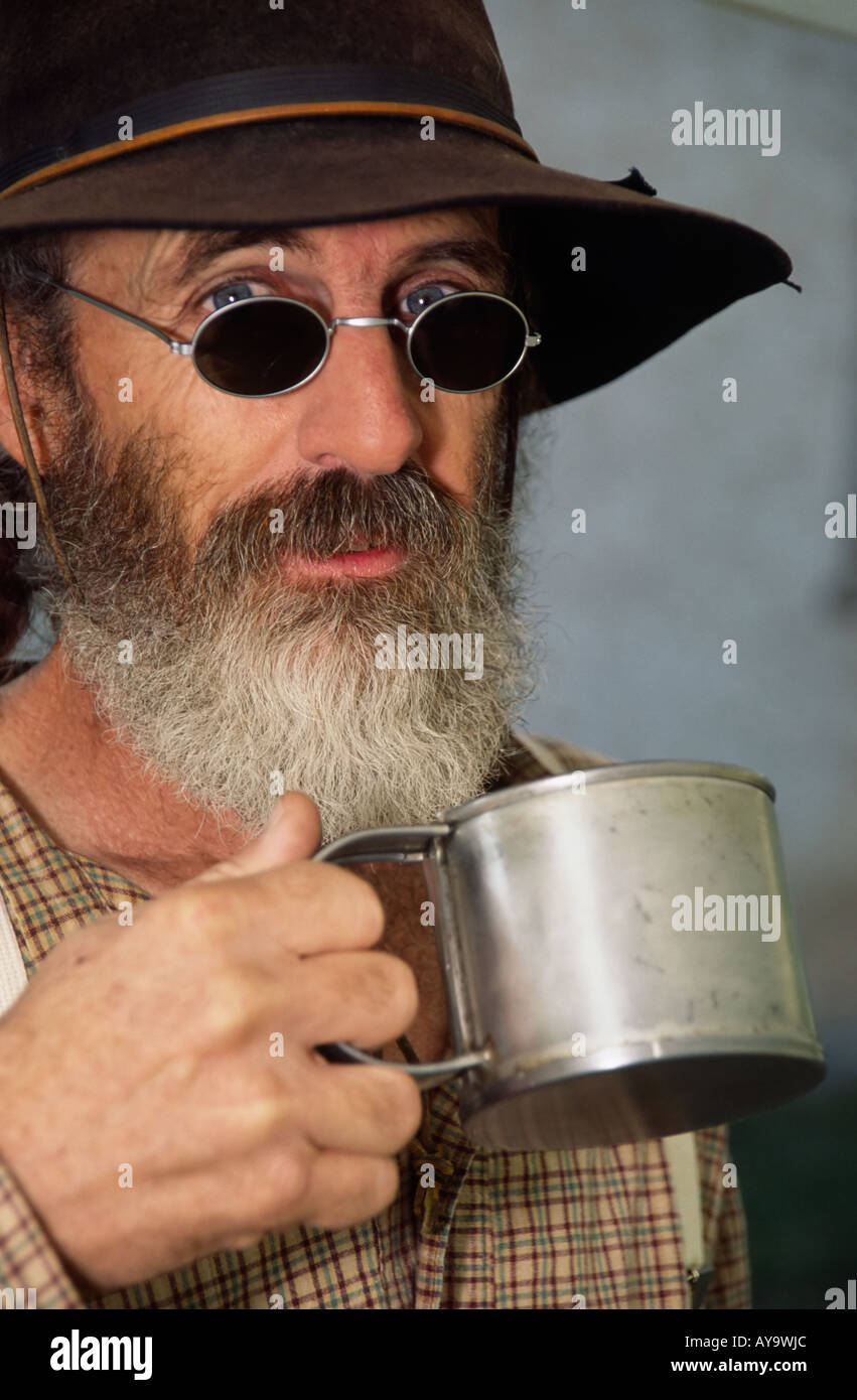 MR 0364 Old wrangler Leonard Clapes drinks cowboy coffee from a battered tin cup in Lincoln, New Mexico. Stock Photo