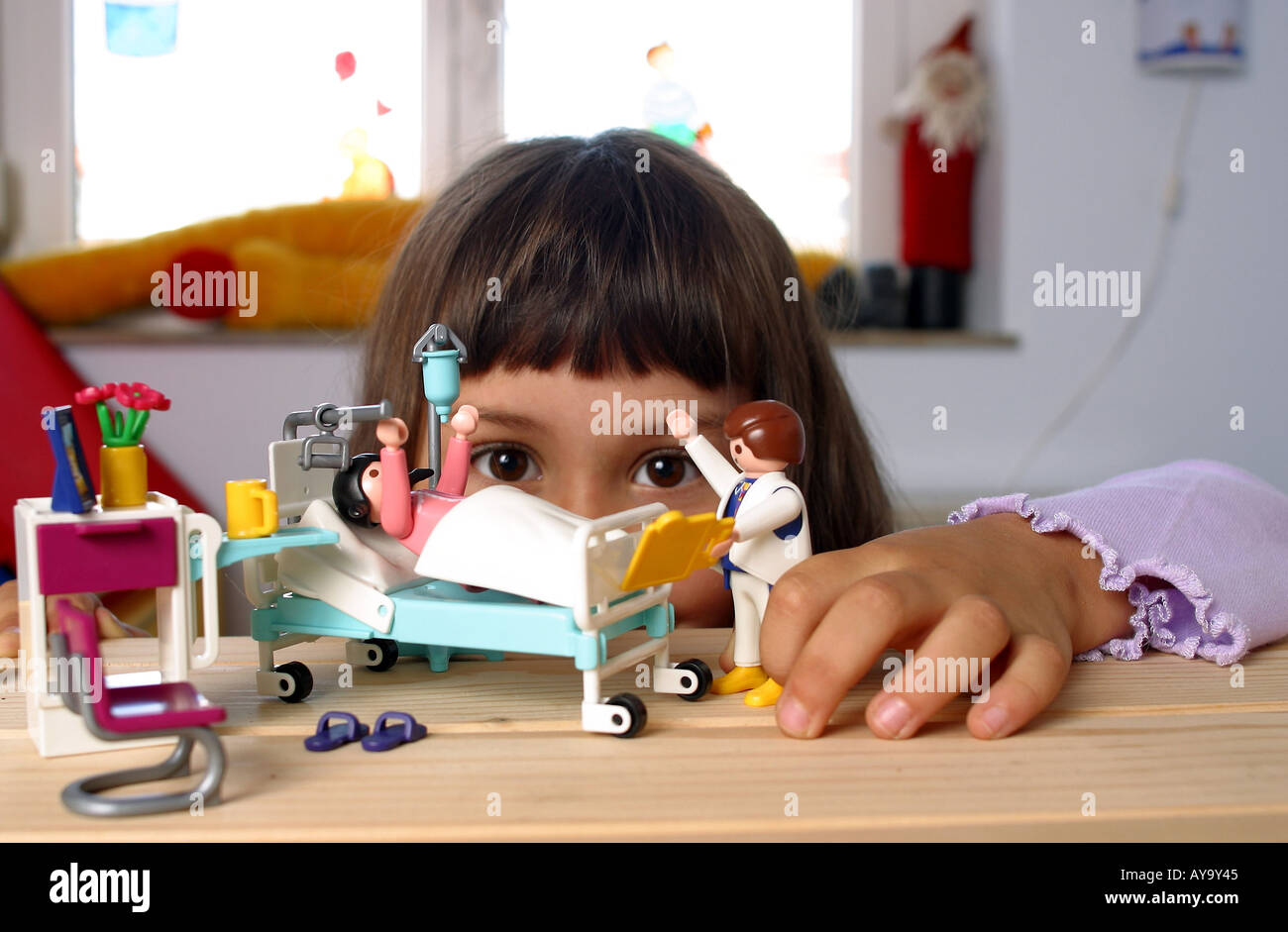 Kind spielt Pflegeszene mit Playmobil Figuren nach Stock Photo