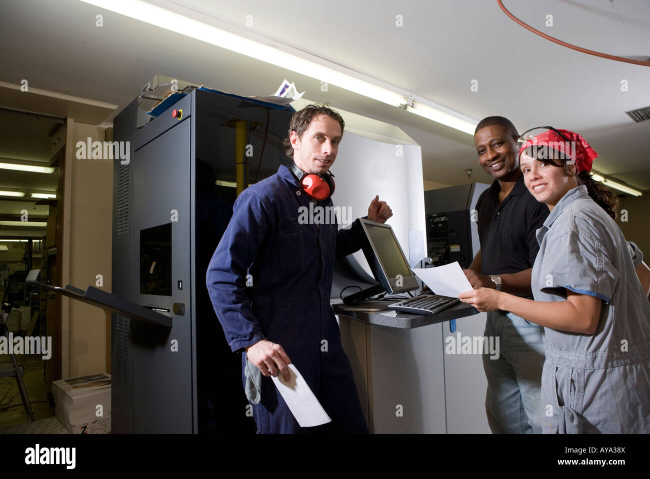 Workers being trained to use a piece of machinery with computer ...