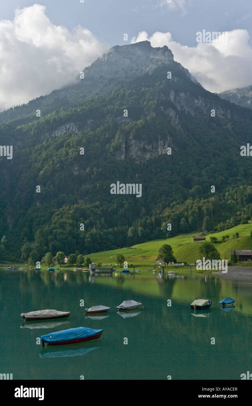Classic European Alpine scene of turquoise lake and moored boats with mountainous backdrop Stock Photo
