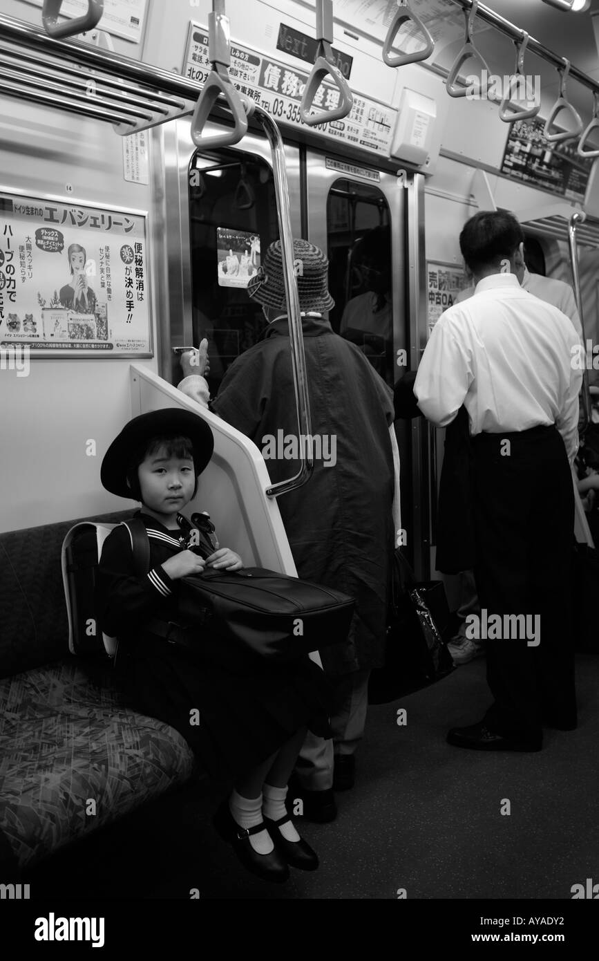 Asia Tokyo Japan Young school girl in uniform on subway train Stock Photo