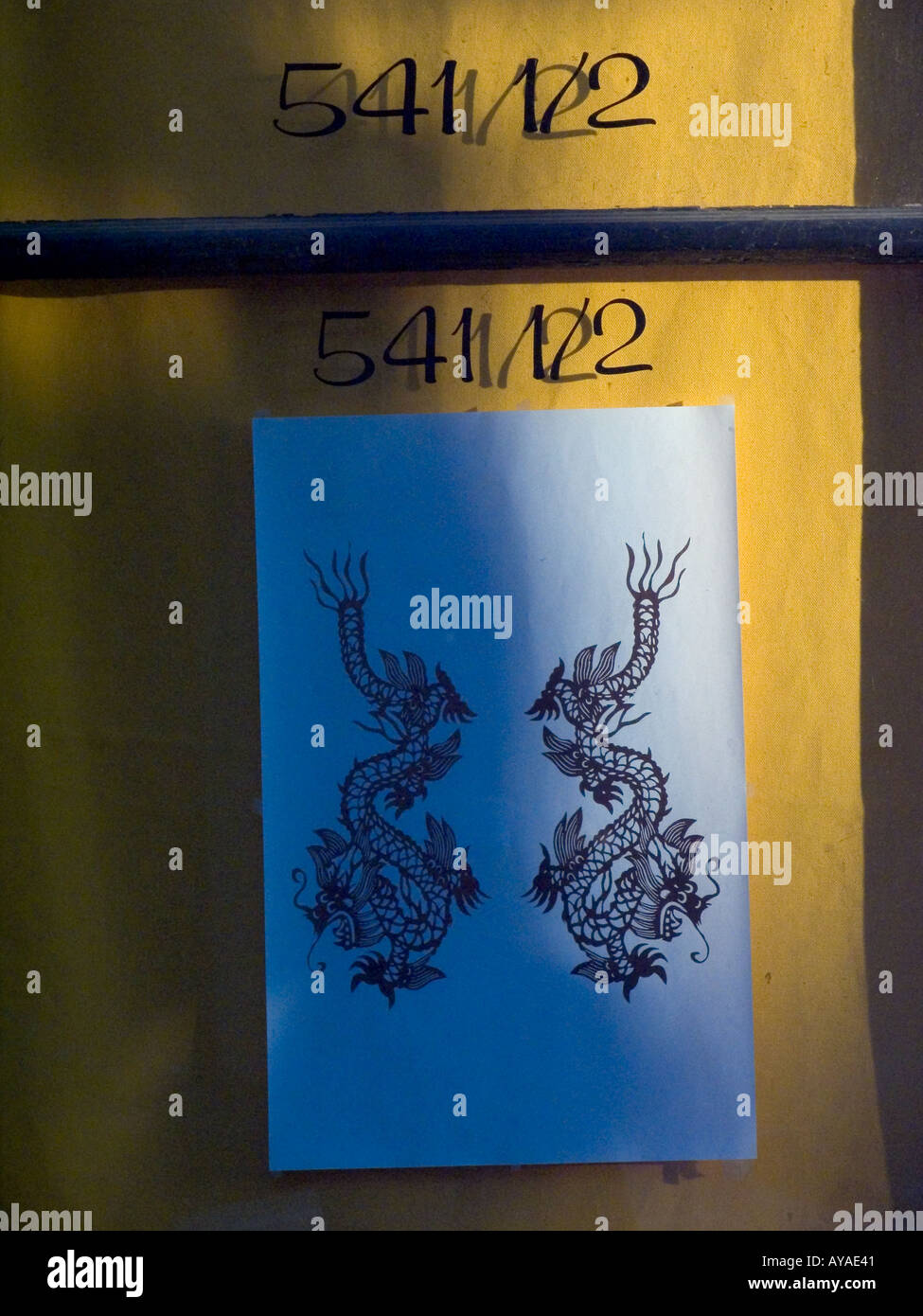 Chinese dragon drawing under address numbers in window of door in