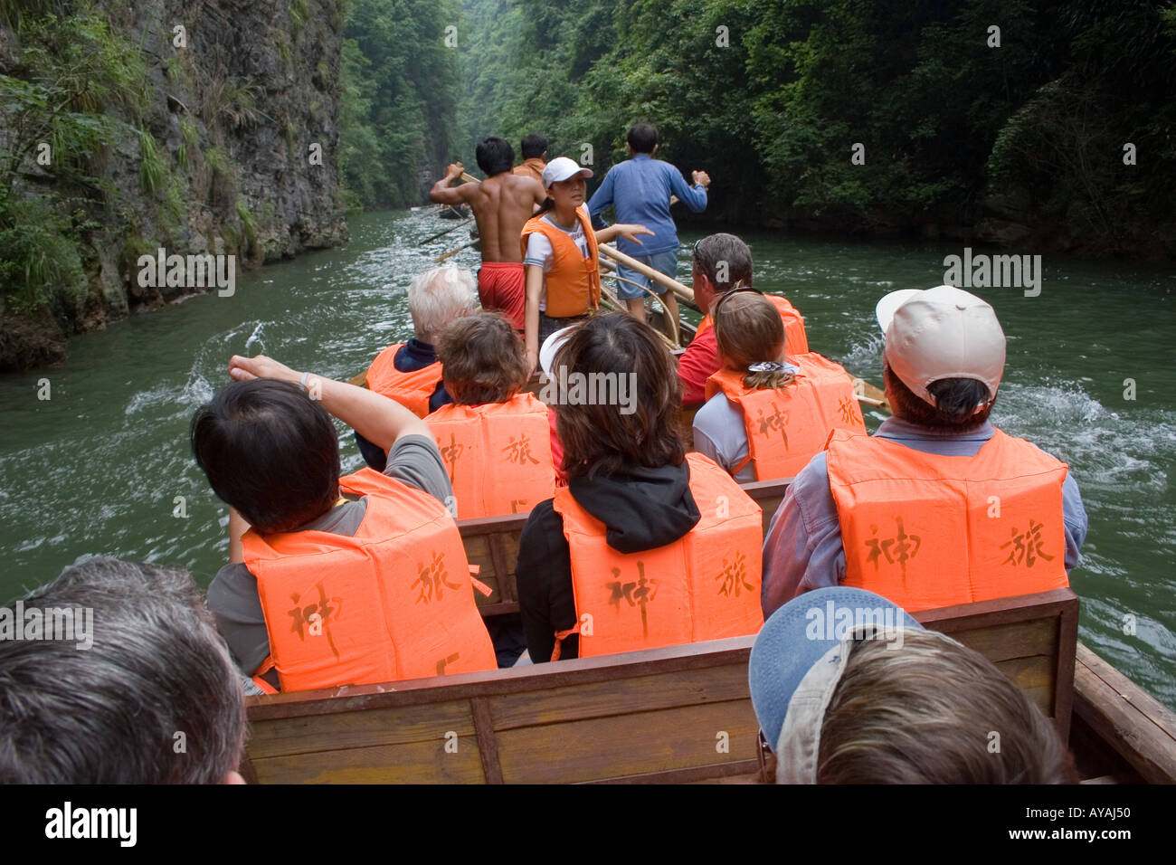 Tourists being rowed upstream on a peapod boat by Chinese fishermen on
