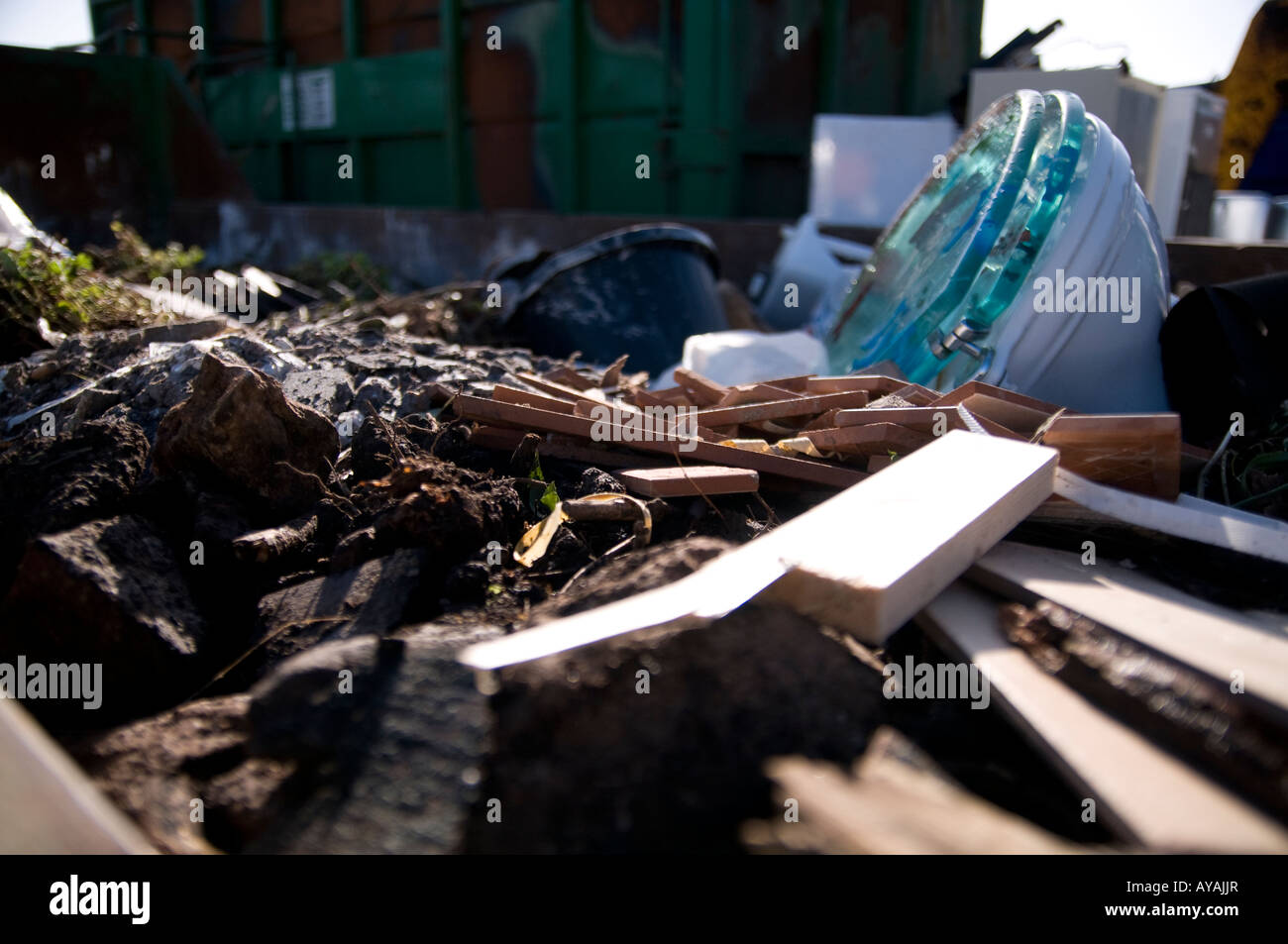 general garden waste, wood earth, mud and a toilet in a skip Stock Photo