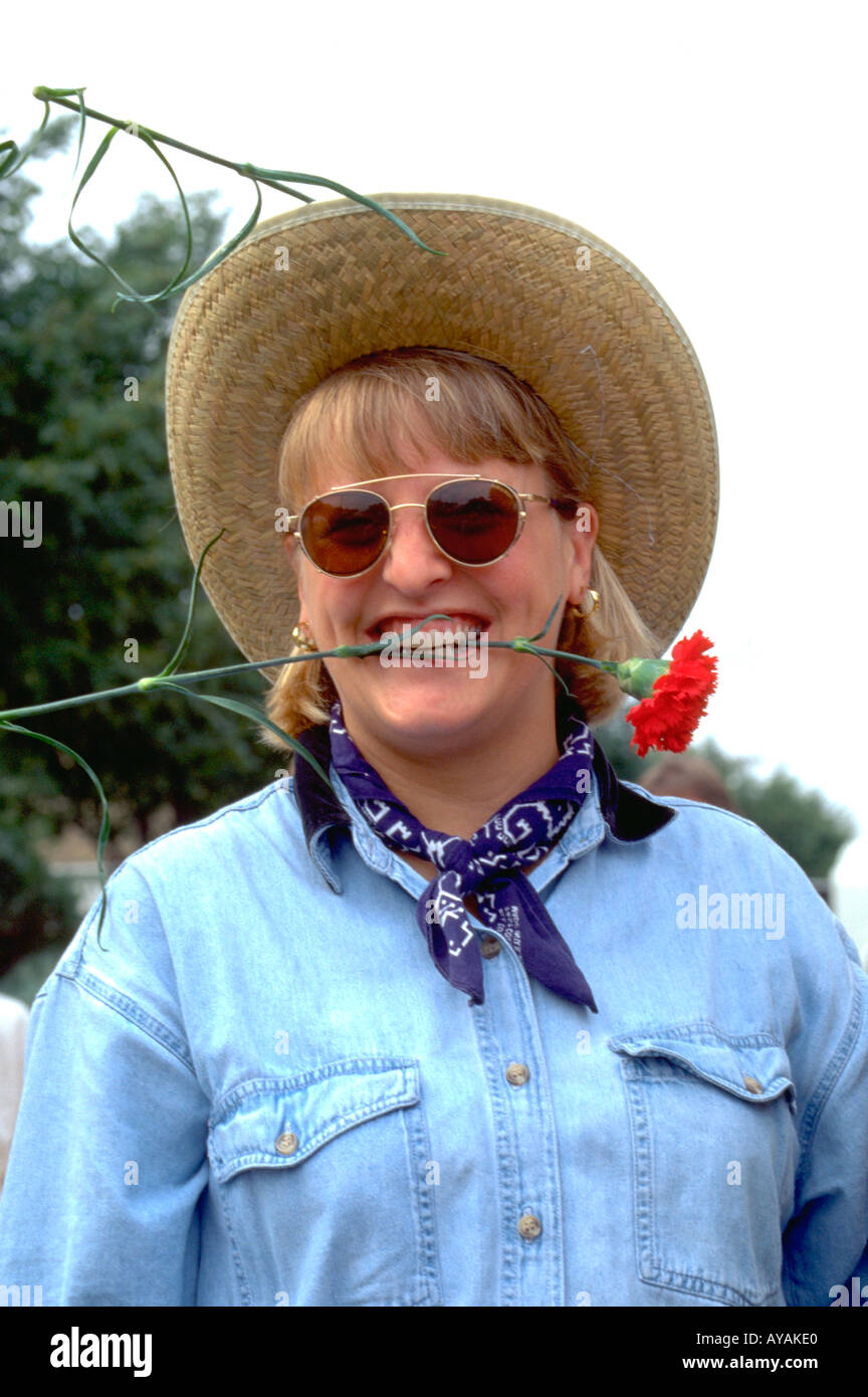 Cowgirl age 39 with rose in teeth at the West End Parade. St Paul Minnesota USA Stock Photo