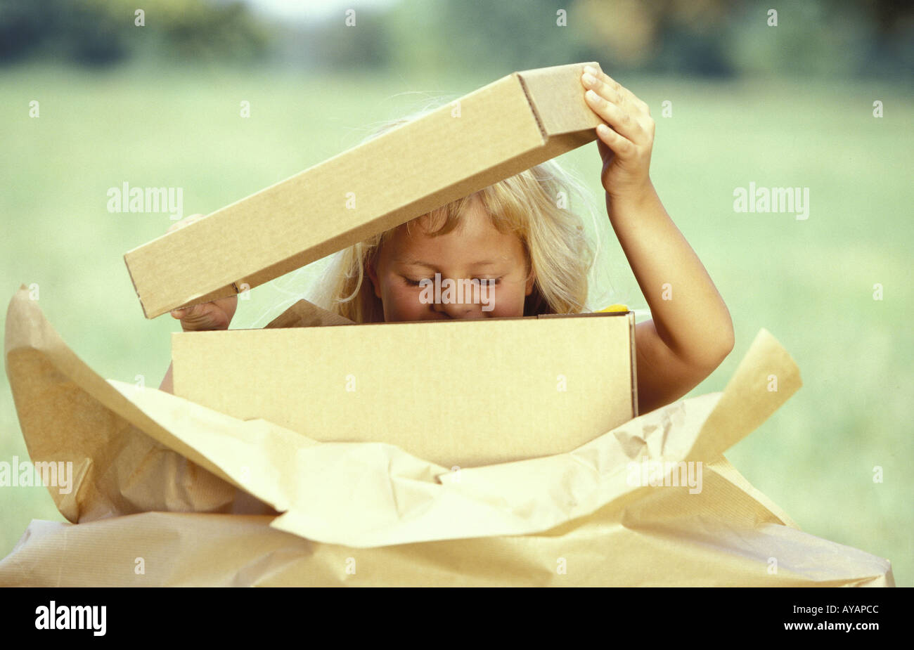 Kleines Maedchen beim Auspacken eines Paketes Stock Photo