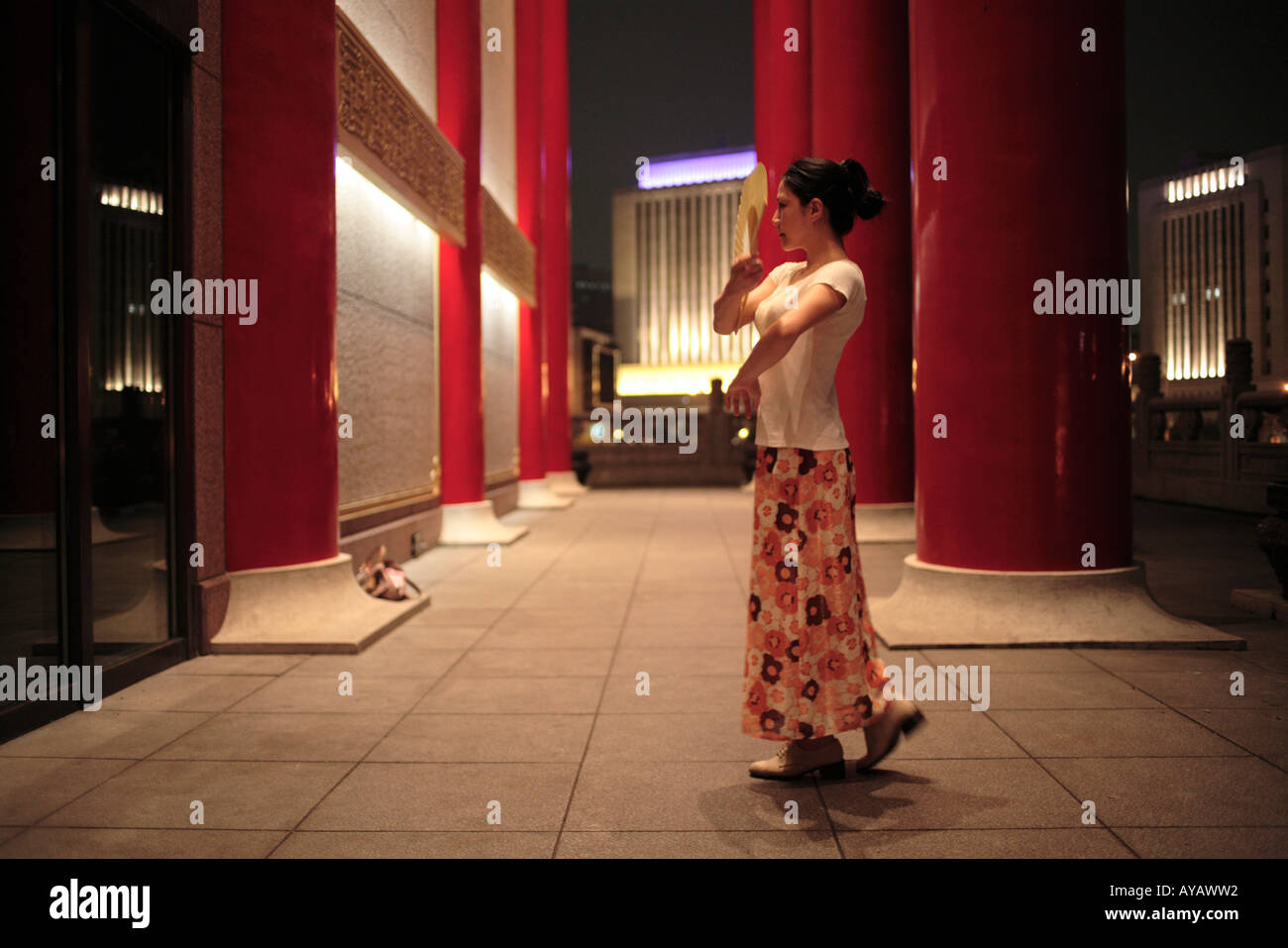 Taiwan Taipei Young woman practice flamenco dancing outside National Theater building at Chiang Kai Shek Memorial at dusk Stock Photo