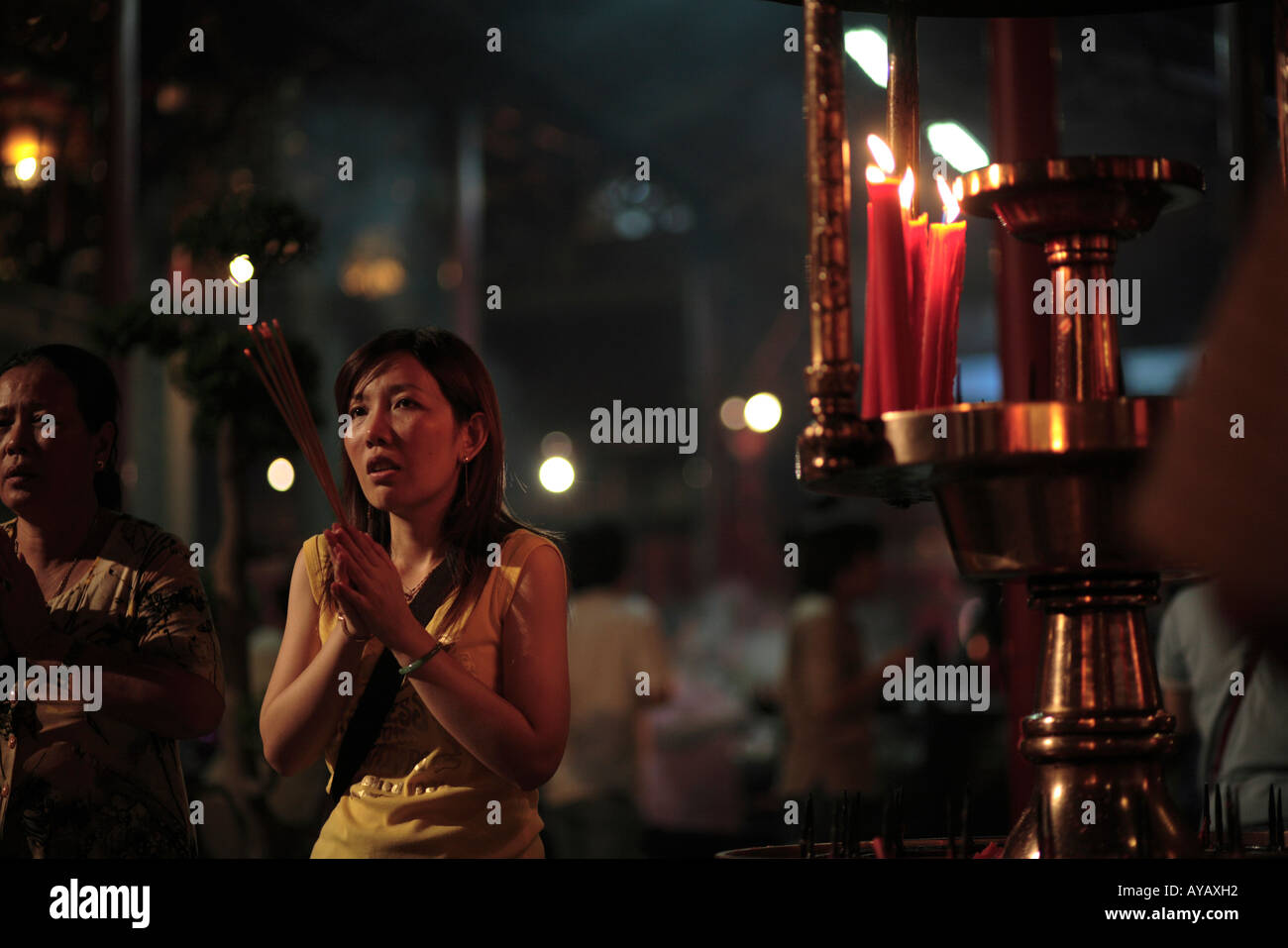 Taiwan Taipei Worshipper burning sticks of incense as offerings inside Long Sham Temple Stock Photo