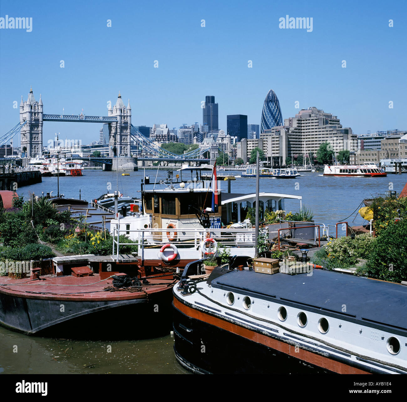 View across River Thames to the City of London and Tower Bridge In the foreground are houseboats Stock Photo