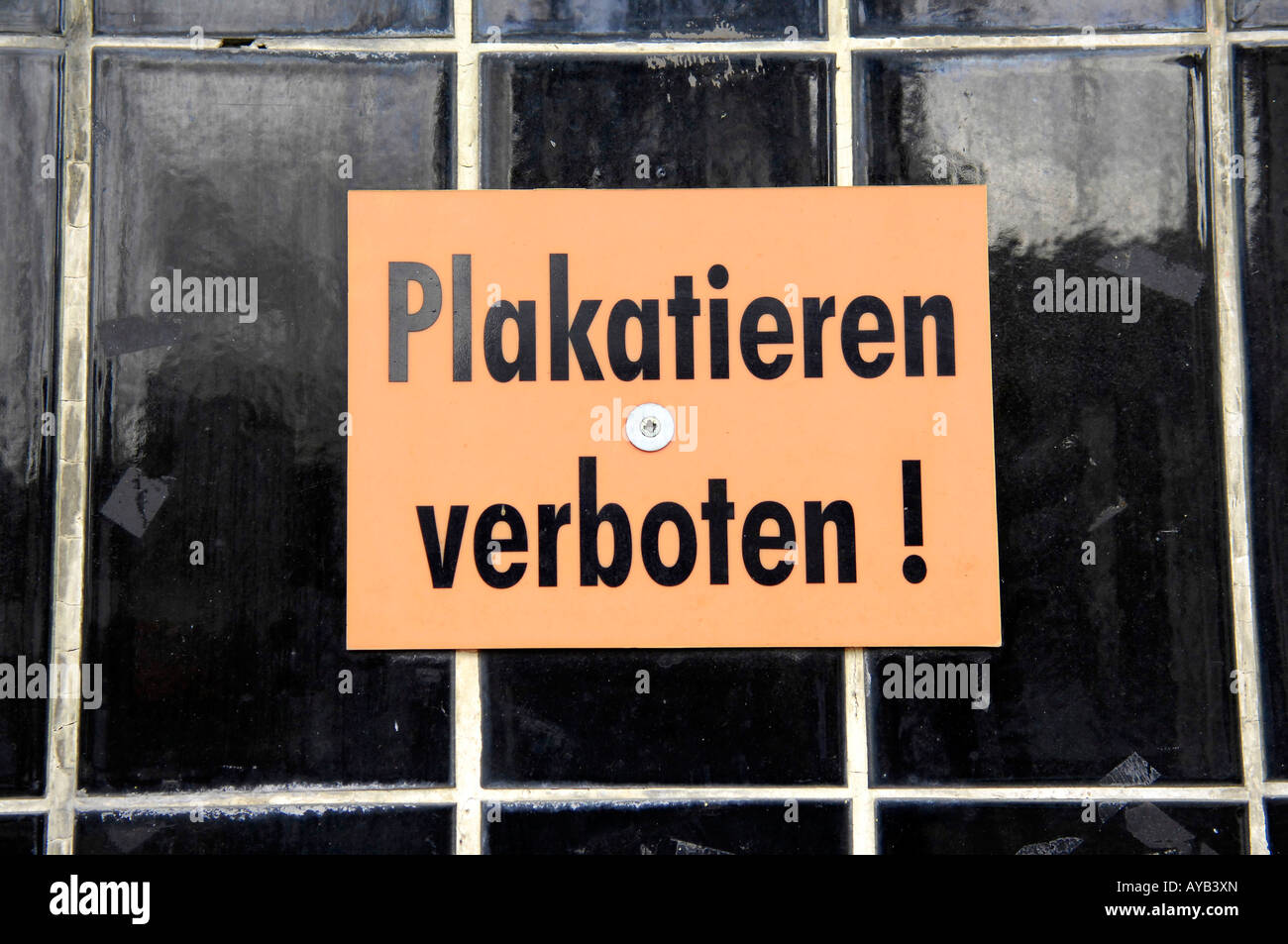 plakatieren verboten bill posters prohibited german deustchland orange black tiled wall street urban law regulations Stock Photo