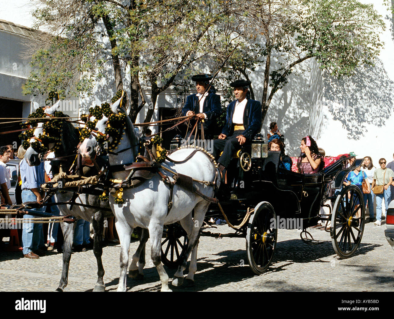 Couples arriving in horsedrawn carriages for a festival in Rhonda Andalucia Spain Stock Photo