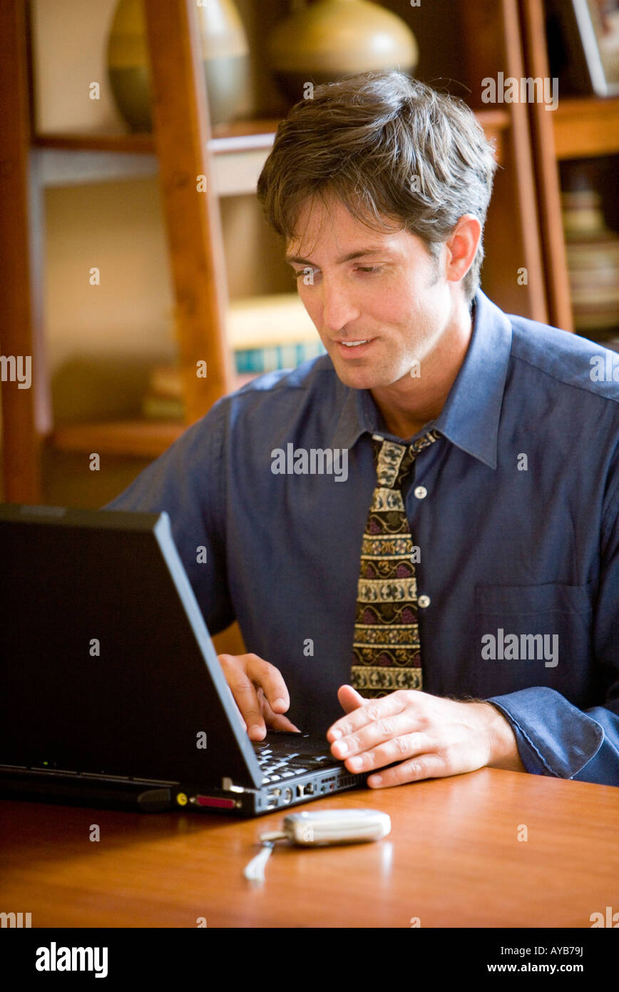 Man using laptop computer in the study of his home Stock Photo - Alamy