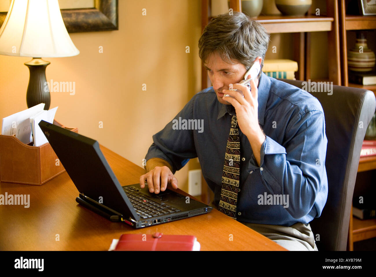 Man using laptop computer in the study of his home Stock Photo - Alamy