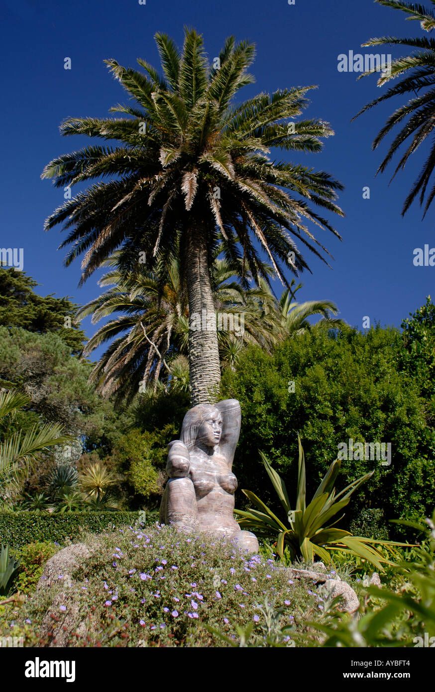 Statue of Gaia the Earth Mother beneath a palm tree on a bright summer