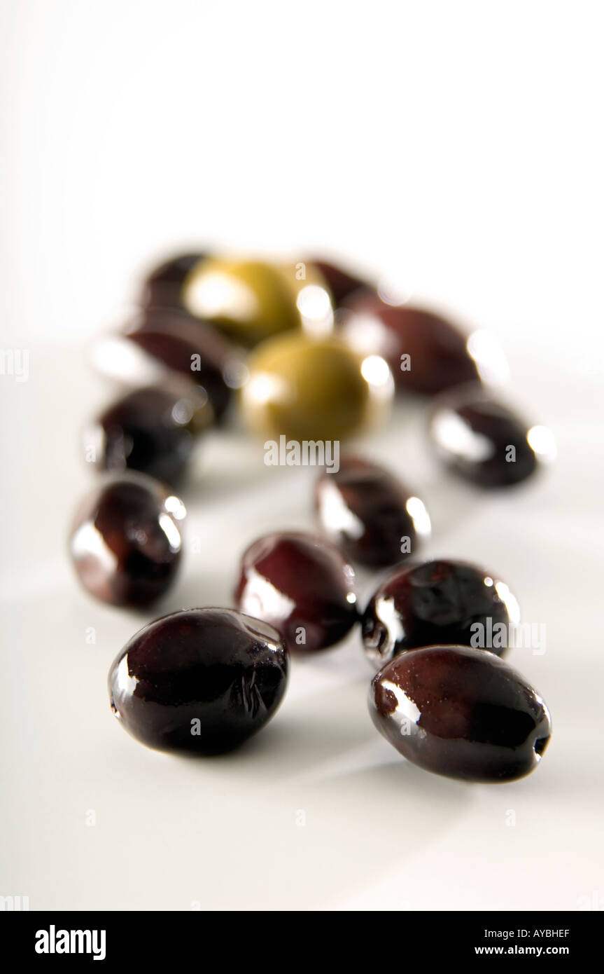 Whole black and green olives shot on a white background with shallow depth of field. Stock Photo