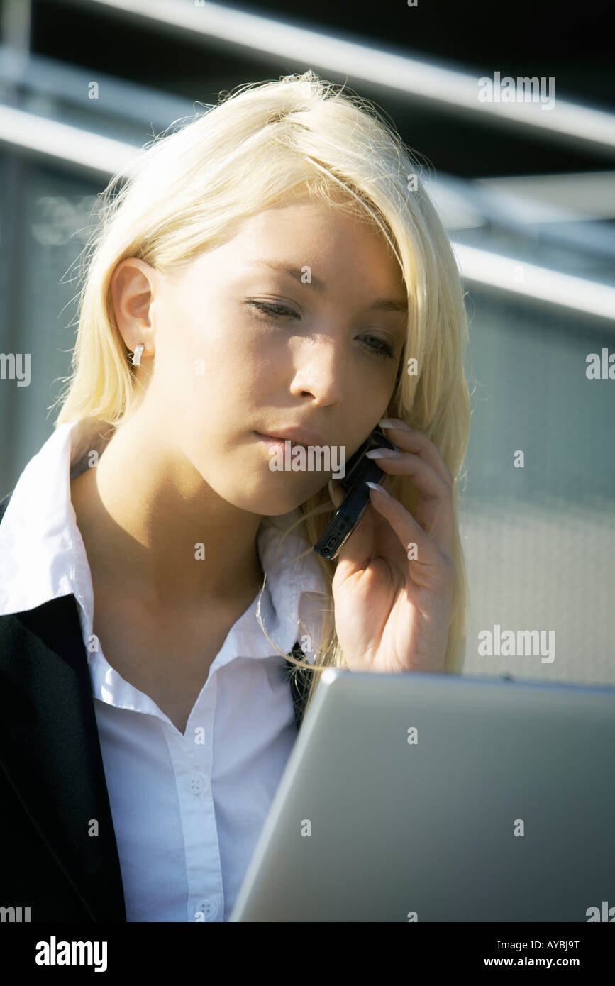 Young businesswoman using laptop computer in city sitting on stairway Stock Photo