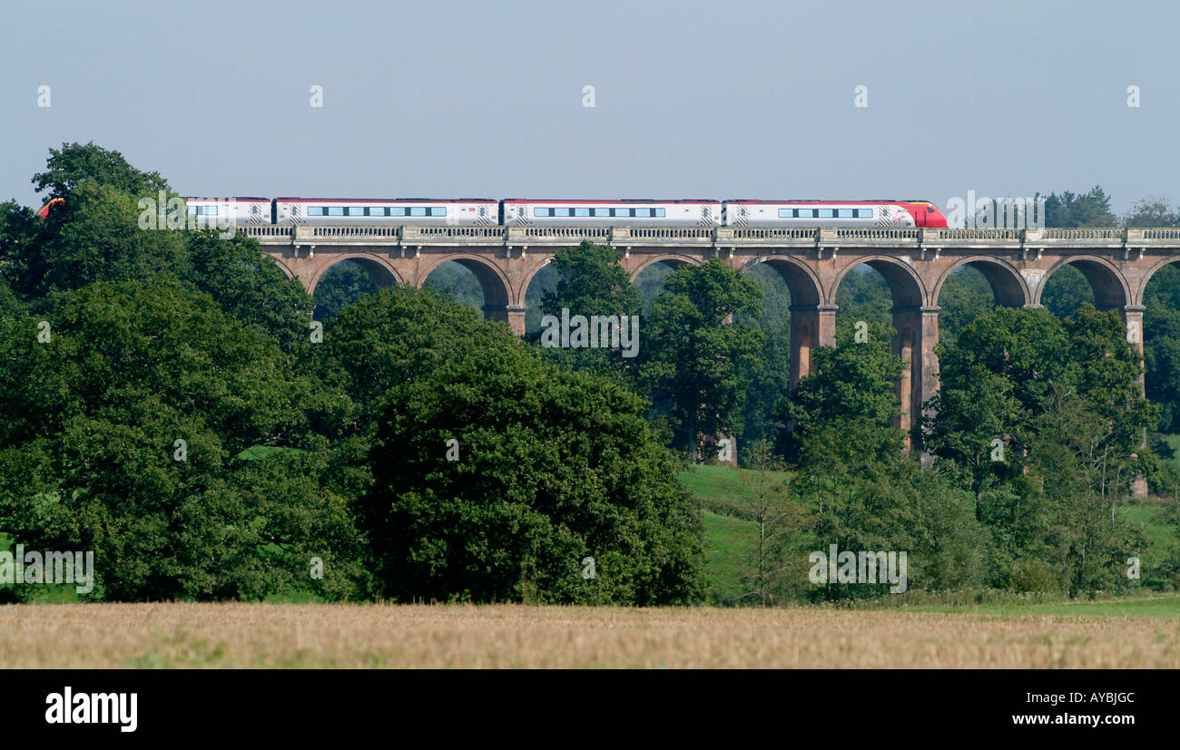 Virgin Voyager train passing over viaduct in the English countryside. Stock Photo