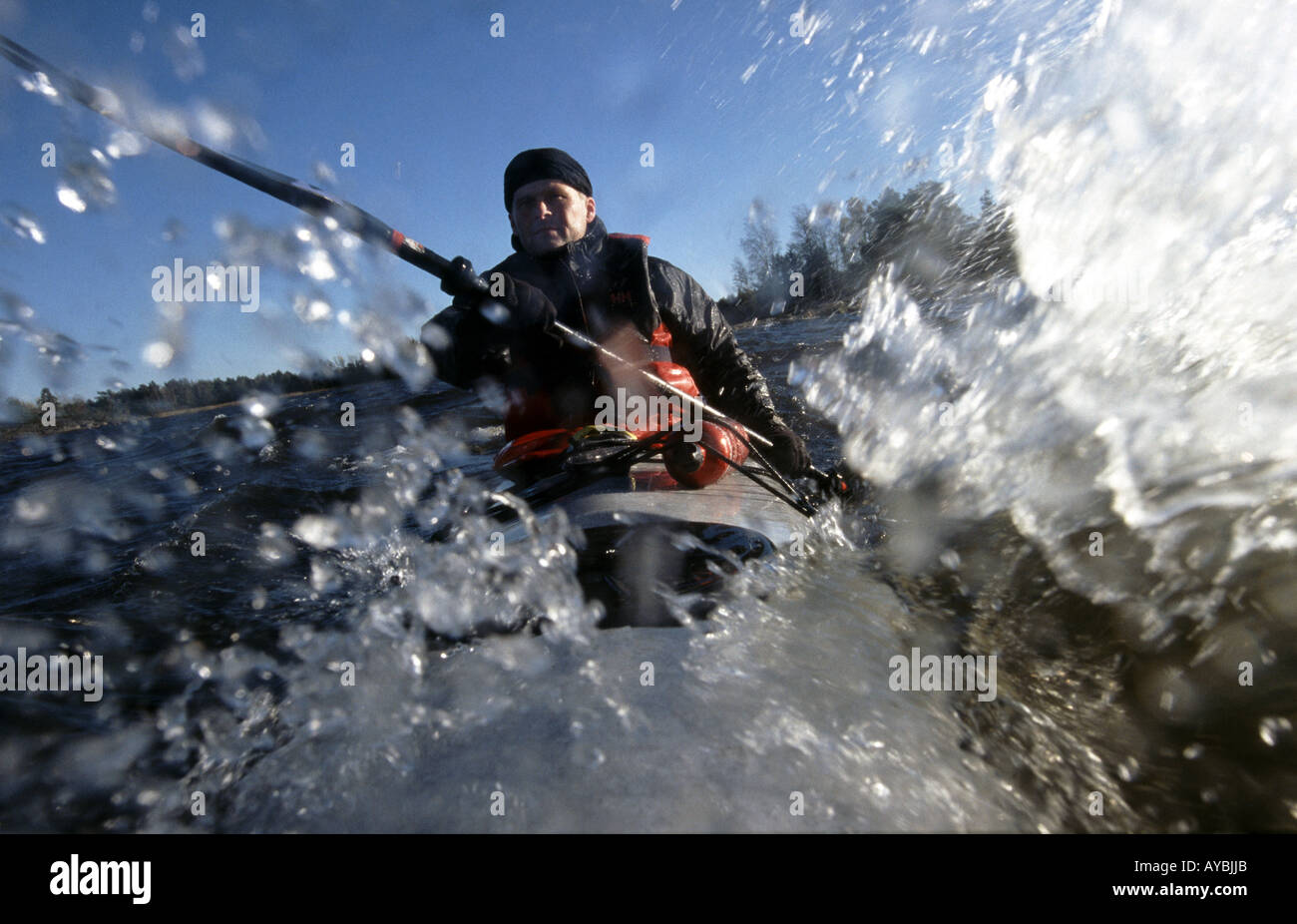 Outdoor photographer Øyvind Martinsen is paddling in his kayak in windy weather on the lake Vansjø, Østfold fylke, Norway. Stock Photo