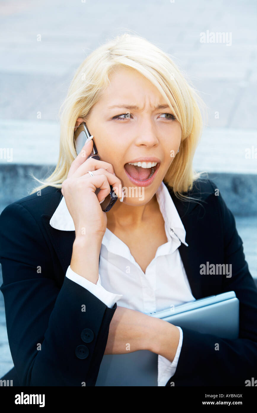 Young businesswoman sitting on stairway using cell phone Stock Photo
